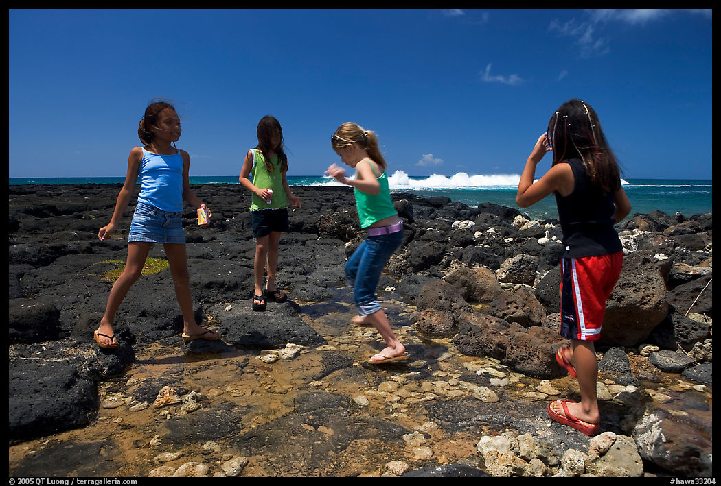 Girls playing in tidepool, Kukuila. Kauai island, Hawaii, USA