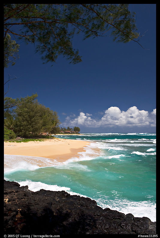 Beach, volcanic rock, and turquoise waters, and homes  near Haena. North shore, Kauai island, Hawaii, USA