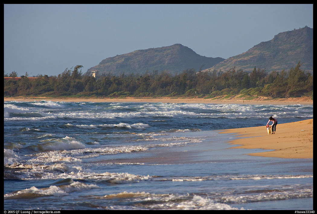 Woman with child on beach, Lydgate Park, early morning. Kauai island, Hawaii, USA