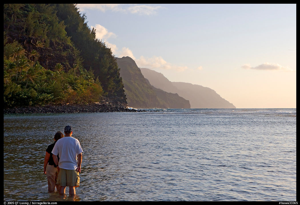 Couple standing in water, Kee Beach, late afternoon. Kauai island, Hawaii, USA
