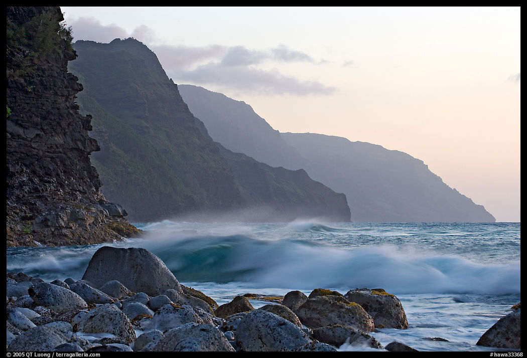 Boulders, waves, and Na Pali Coast, sunset. Kauai island, Hawaii, USA