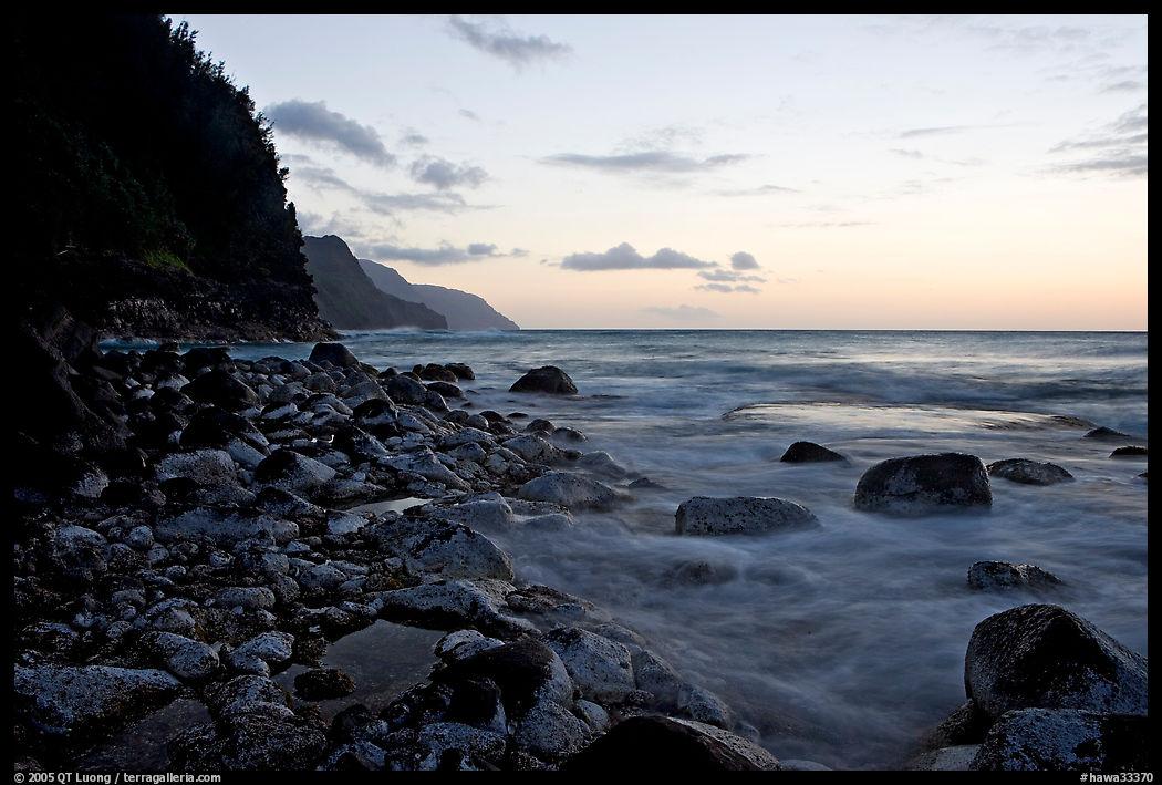 Boulders, waves, and Na Pali Coast, sunset. Kauai island, Hawaii, USA