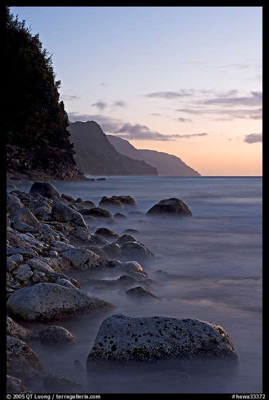 Boulders, surf, and Na Pali Coast, sunset. Kauai island, Hawaii, USA