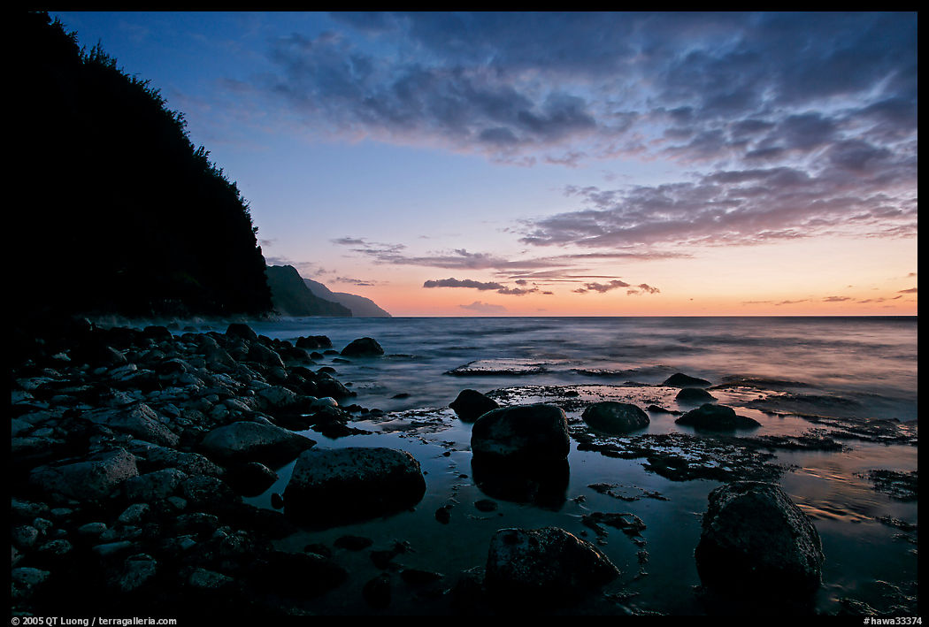 Boulders, surf, and Na Pali Coast, dusk. Kauai island, Hawaii, USA