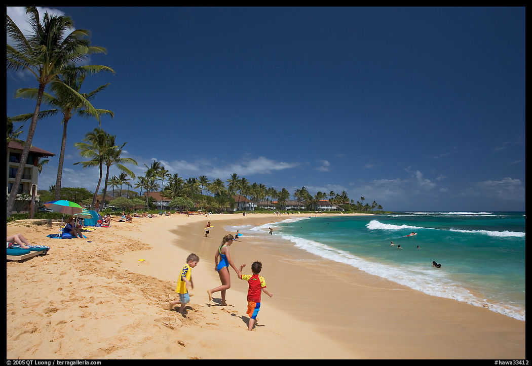 Children playing around, Kiahuna Beach, mid-day. Kauai island, Hawaii, USA