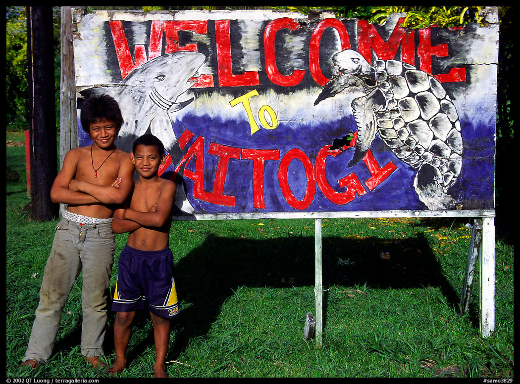 Children in front of a turtle a shark sign in Vaitogi. Tutuila, American Samoa