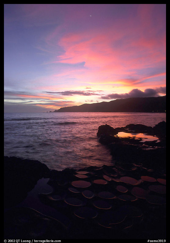 Water-filled  grinding stones holes (foaga) and Leone Bay at sunset. Tutuila, American Samoa