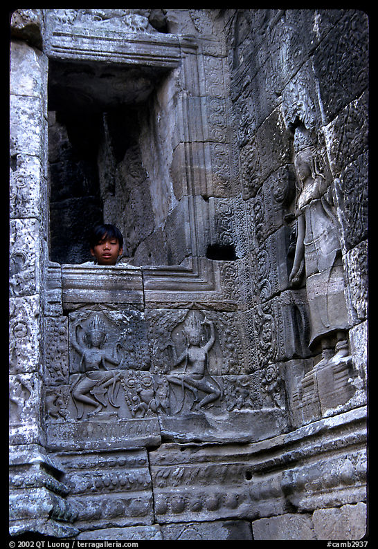Boy hides in the Bayon. Angkor, Cambodia