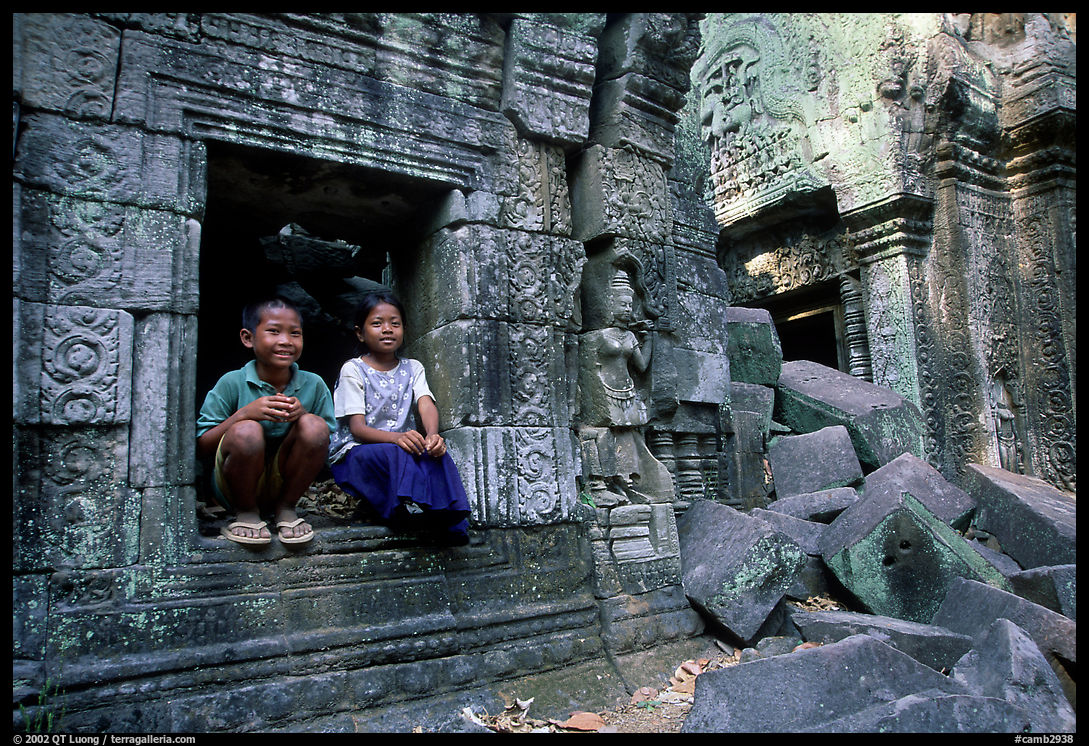 Boy and girl sit at window in Ta Prom. Angkor, Cambodia