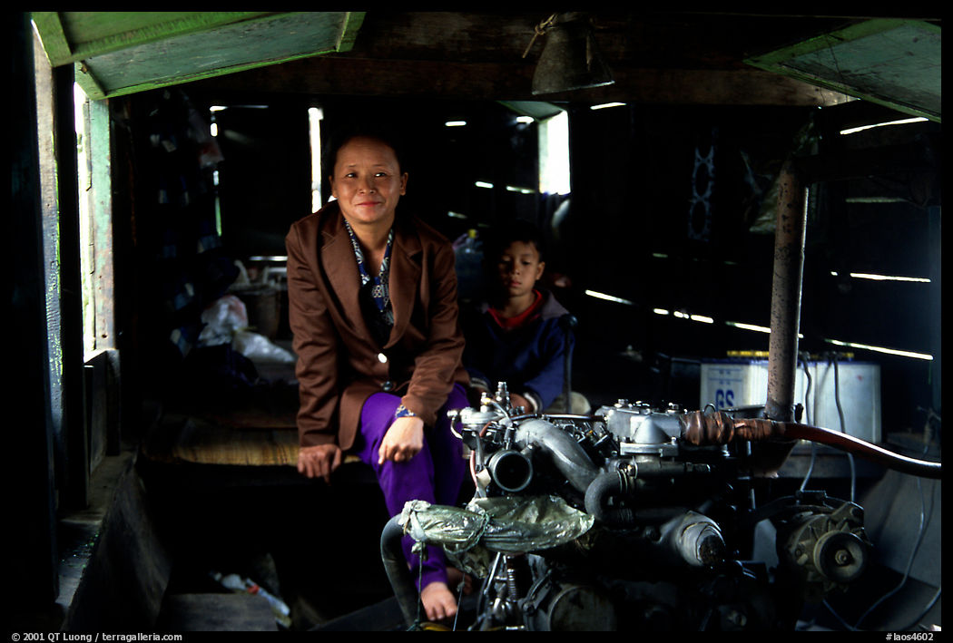 Engine and pilot at the rear of a slow passenger boat. Mekong river, Laos