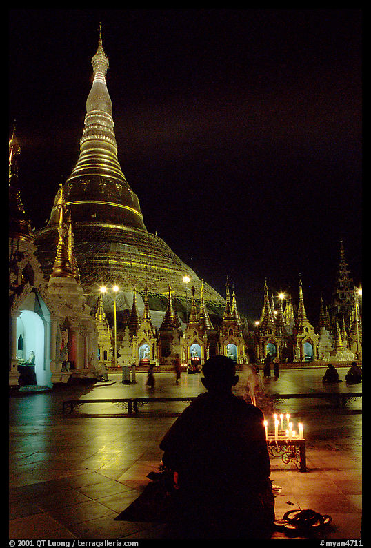Praying at the wish-fullfilling place by night , Shwedagon Paya. Yangon, Myanmar