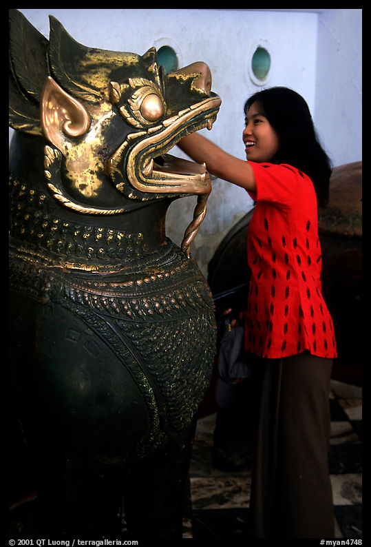Rubbing an Angkor bronze statue at Mahamuni Paya. Mandalay, Myanmar