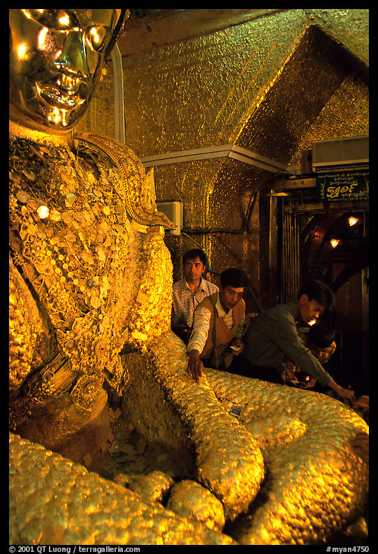 Adding golden leaves to the venerated Mahamuni image. Mandalay, Myanmar