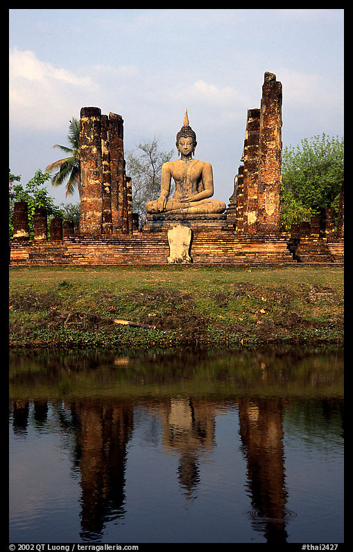Buddha image reflected in moat, morning, Wat Mahathat. Sukothai, Thailand