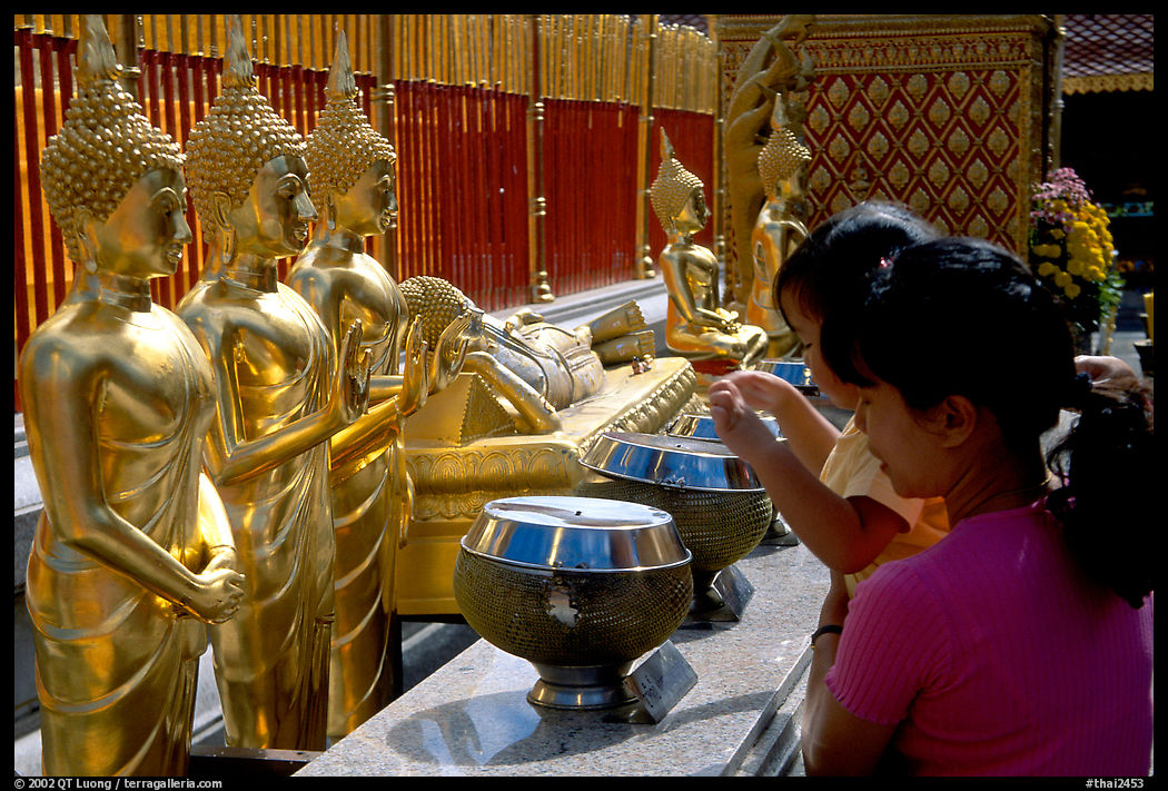 Worshiper makes offering at Wat Phra That Doi Suthep. Chiang Mai area, Thailand