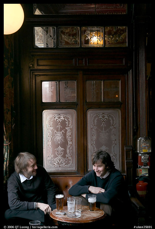 Young men, beer pints, and etched glass, pub Princess Louise. London, England, United Kingdom