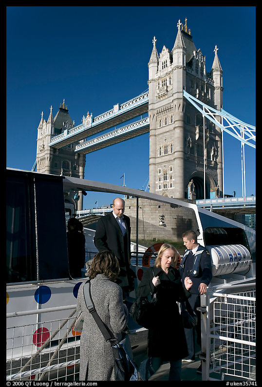 Passengers disembarking a boat in their morning commute, Tower Bridge in the background. London, England, United Kingdom