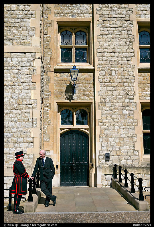 Yeoman Warder talking with man in suit in front of the Jewel House, Tower of London. London, England, United Kingdom