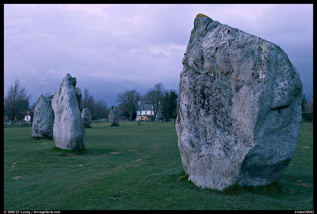 Standing stone circle and village house at dusk, Avebury, Wiltshire. England, United Kingdom