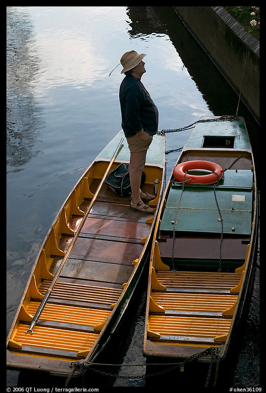 Man standing in a rowboat, old town moat. Canterbury,  Kent, England, United Kingdom