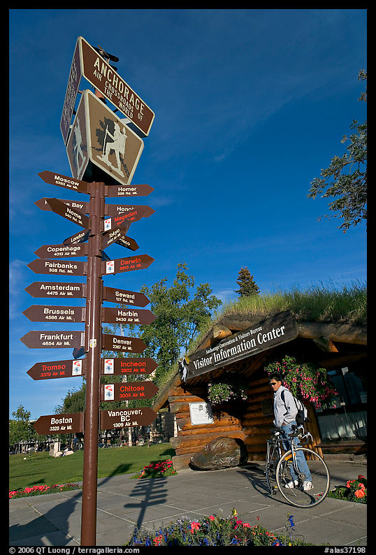 Sign Air Crossroads of the World, man on bicycle in front of visitor center. Anchorage, Alaska, USA