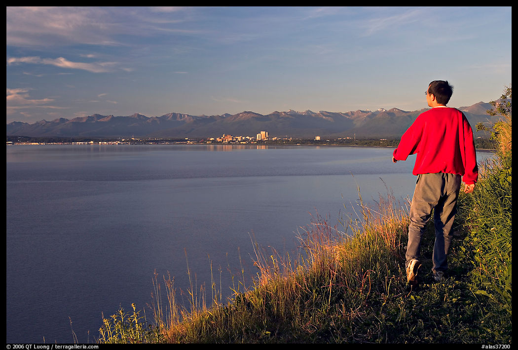 Man walking on the edge of Knik Arm in Earthquake Park, sunset. Anchorage, Alaska, USA