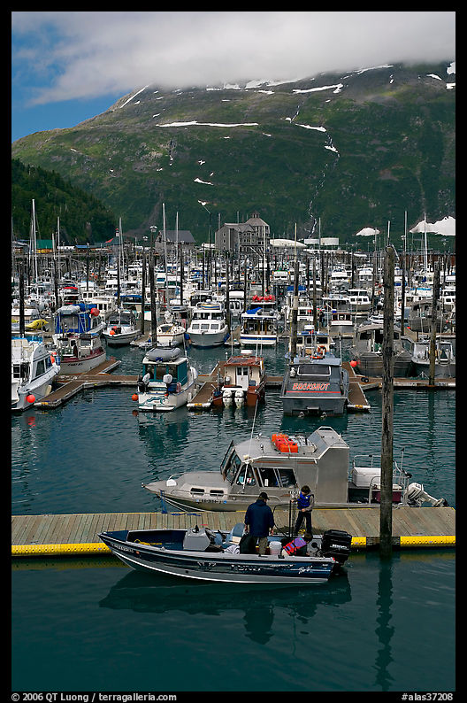 Small boat loaded at pier, harbor, and mountains. Whittier, Alaska, USA