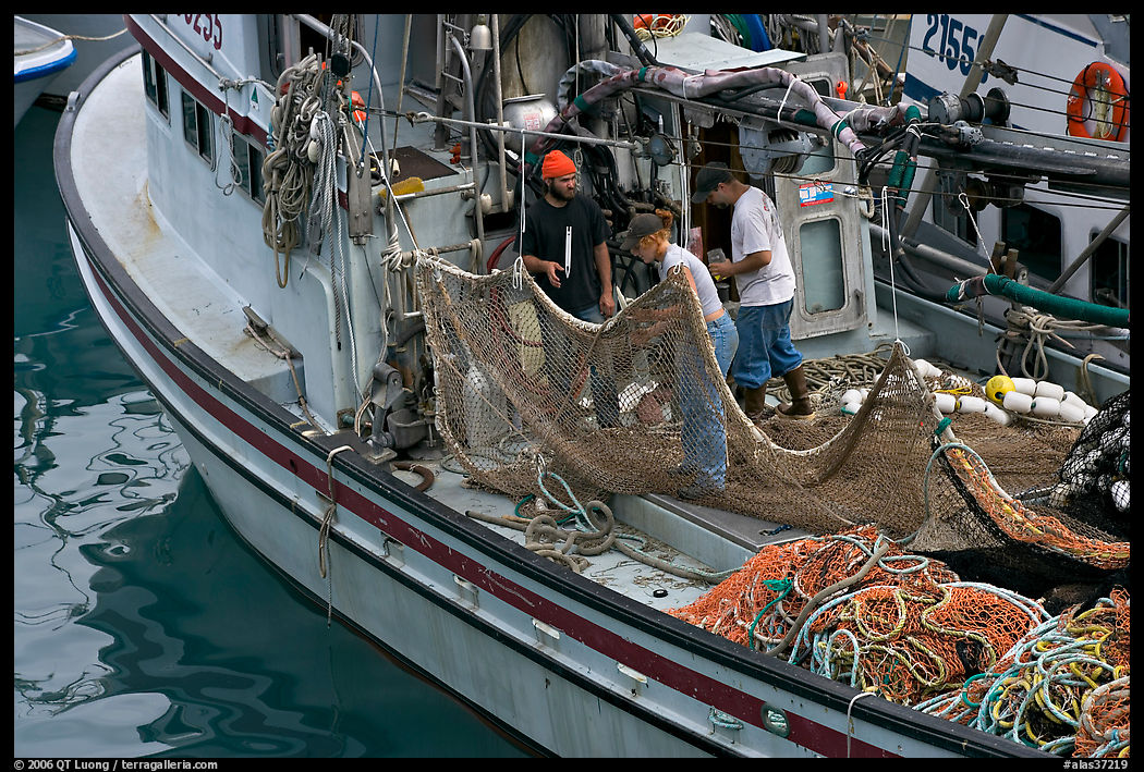Fishermen repairing nets on fishing boat. Whittier, Alaska, USA