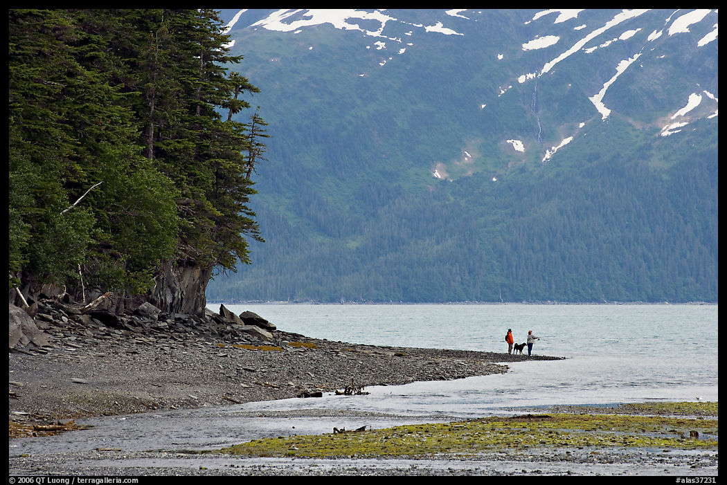 Women fishing and dog, at the edge of Passage Canal Fjord. Whittier, Alaska, USA