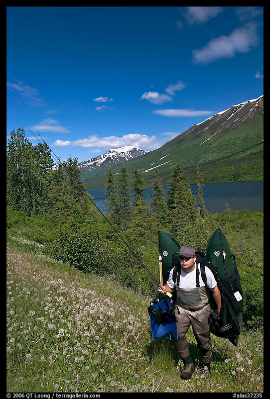 Fisherman hiking out from lake with full gear. Seward Highway, Kenai Peninsula, Alaska, USA