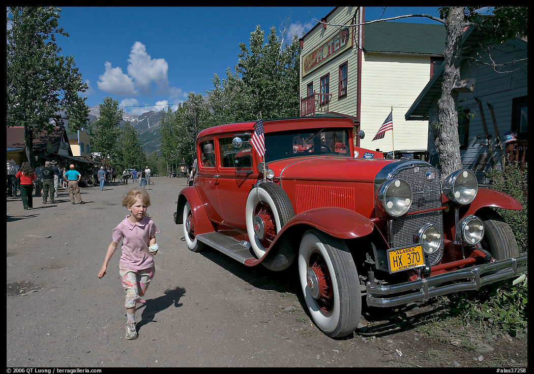 Girl on main street with red classic car. McCarthy, USA