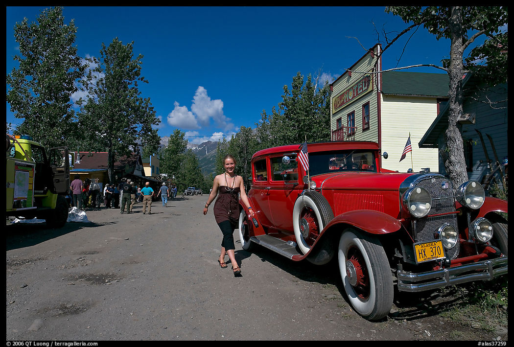 Woman walking next to red classic car. McCarthy, USA