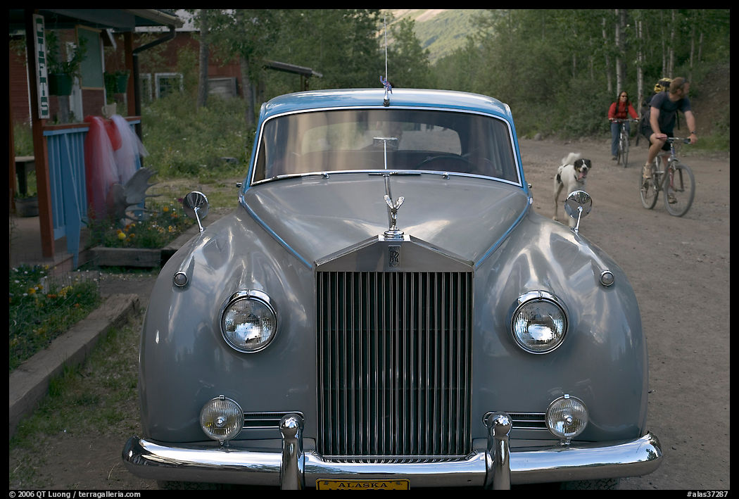 Rolls Royce on dirt road with mountain bikers in background. McCarthy, USA