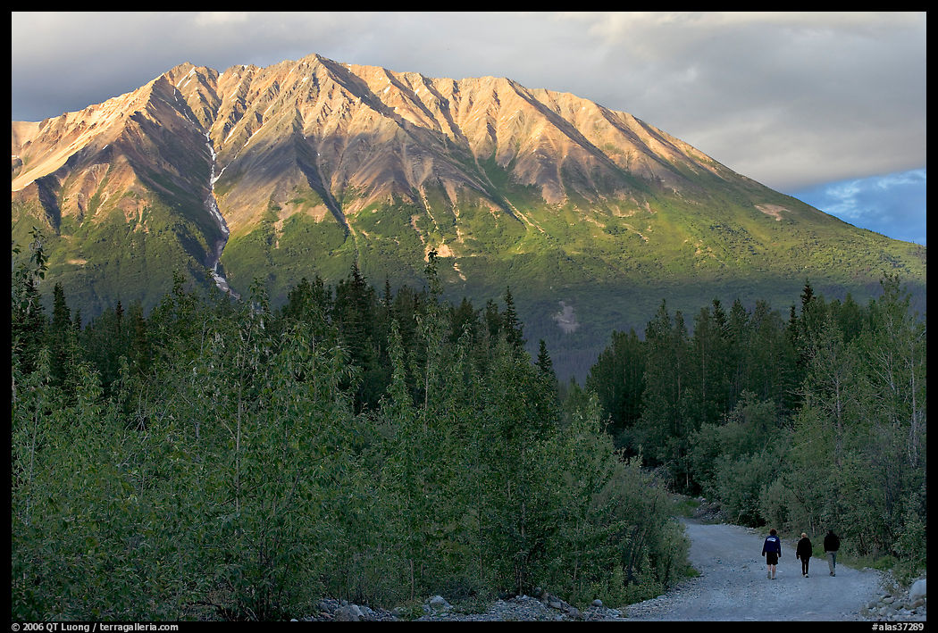 People strolling on unpaved road at sunset. McCarthy, USA