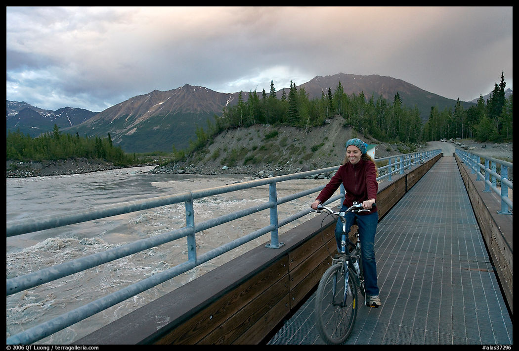 Woman on mountain bike crossing the footbridge. McCarthy, USA
