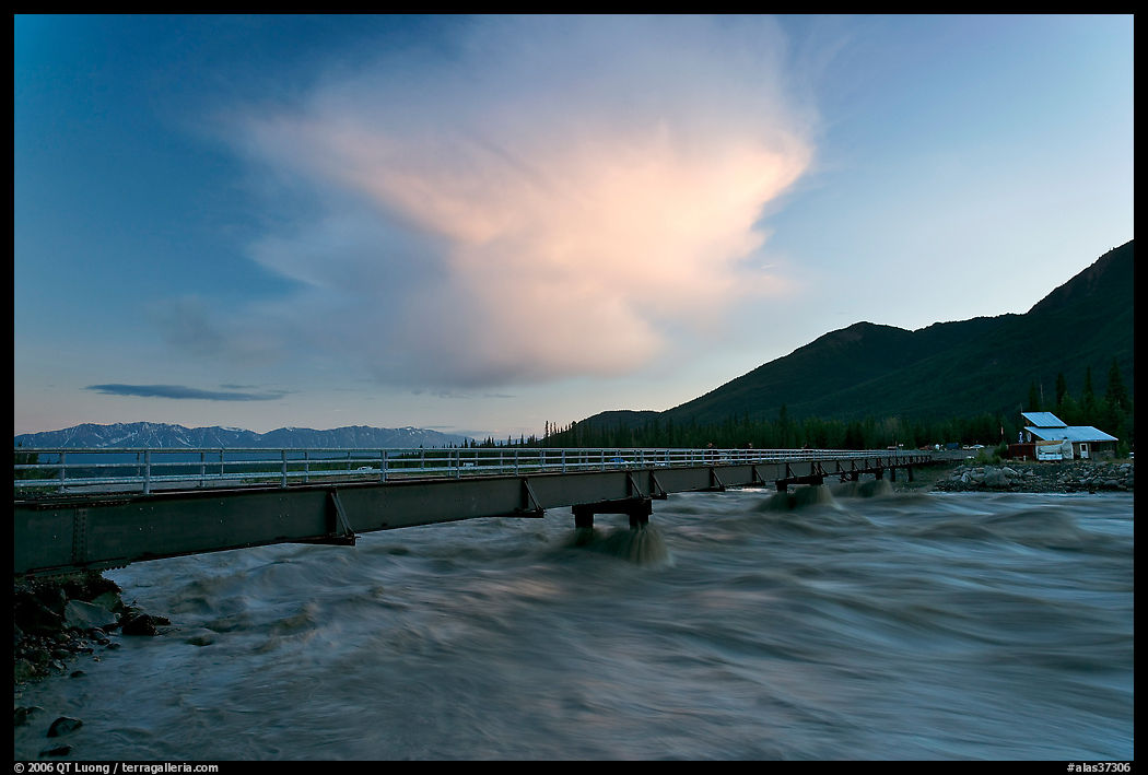Kennicott River swelled from the Hidden Lake flood rushing against footbridge, sunset. McCarthy, USA