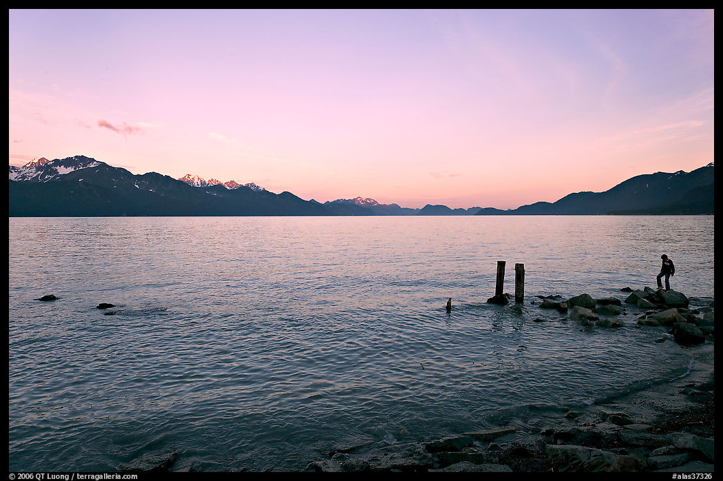Boy standing in front of Resurrection Bay, sunset. Seward, Kenai Peninsula, Alaska, USA