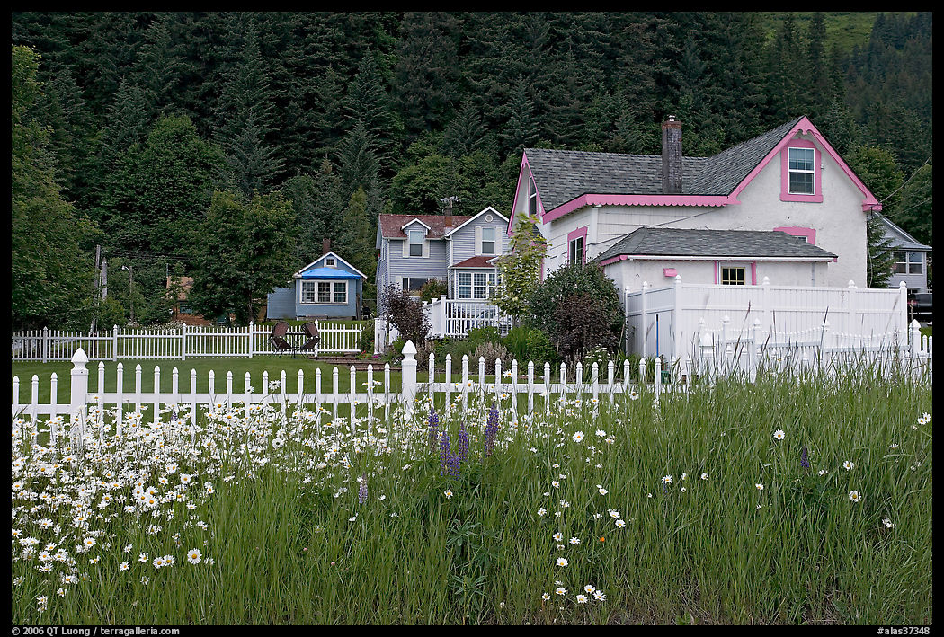 White picket fence and houses with pastel trims. Seward, Kenai Peninsula, Alaska, USA