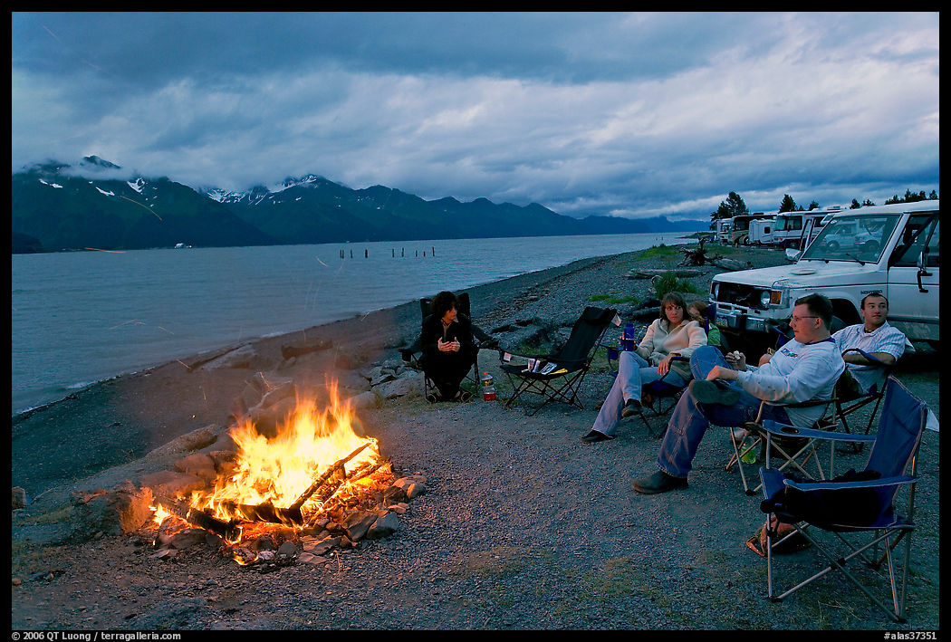 Sitting by campfire at midnight, waterfront campground. Seward, Kenai Peninsula, Alaska, USA