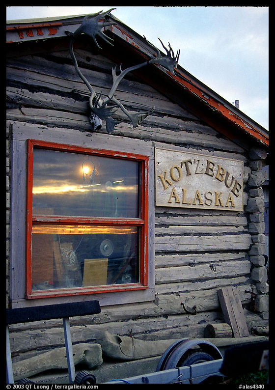 Log cabin with caribou antlers and sun reflected in window. Kotzebue, North Western Alaska, USA