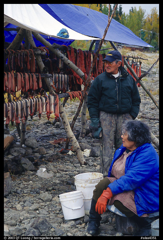 Inupiaq Eskimo man and woman next to fish hung for drying, Ambler. North Western Alaska, USA