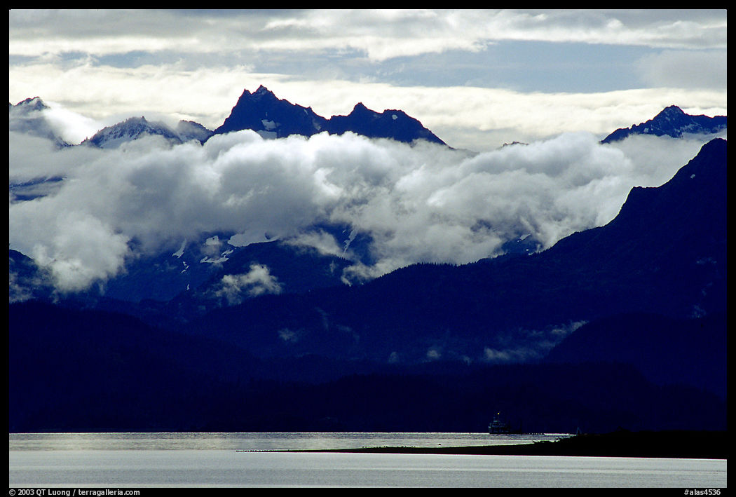 Mountains rising above bay with low clouds. Homer, Kenai Peninsula, Alaska, USA