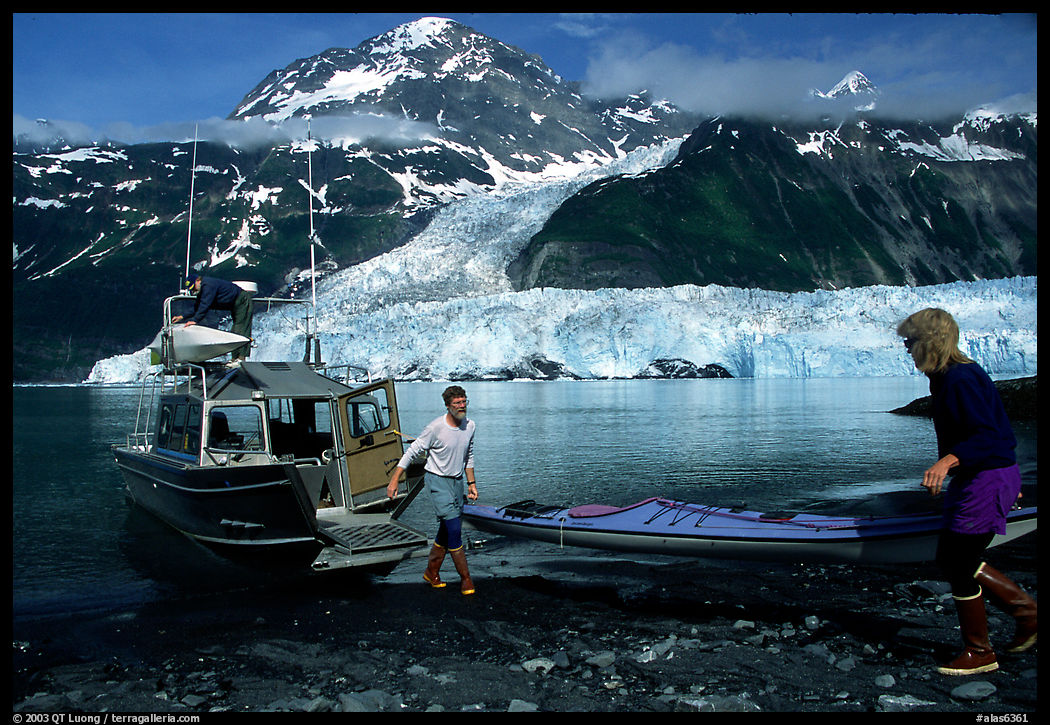 Kayakers unload  kayak from  water taxi boat at Black Sand Beach. Prince William Sound, Alaska, USA