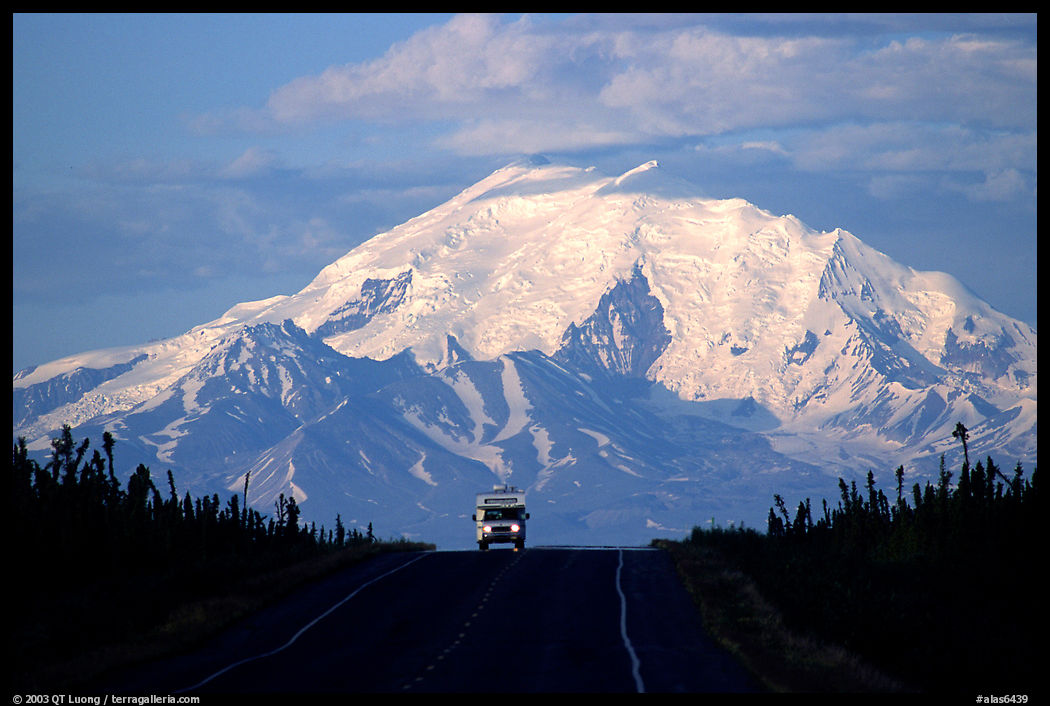 Car on road with a peak of the Wrangell range in the background. Glenn Highway, Central Alaska, USA
