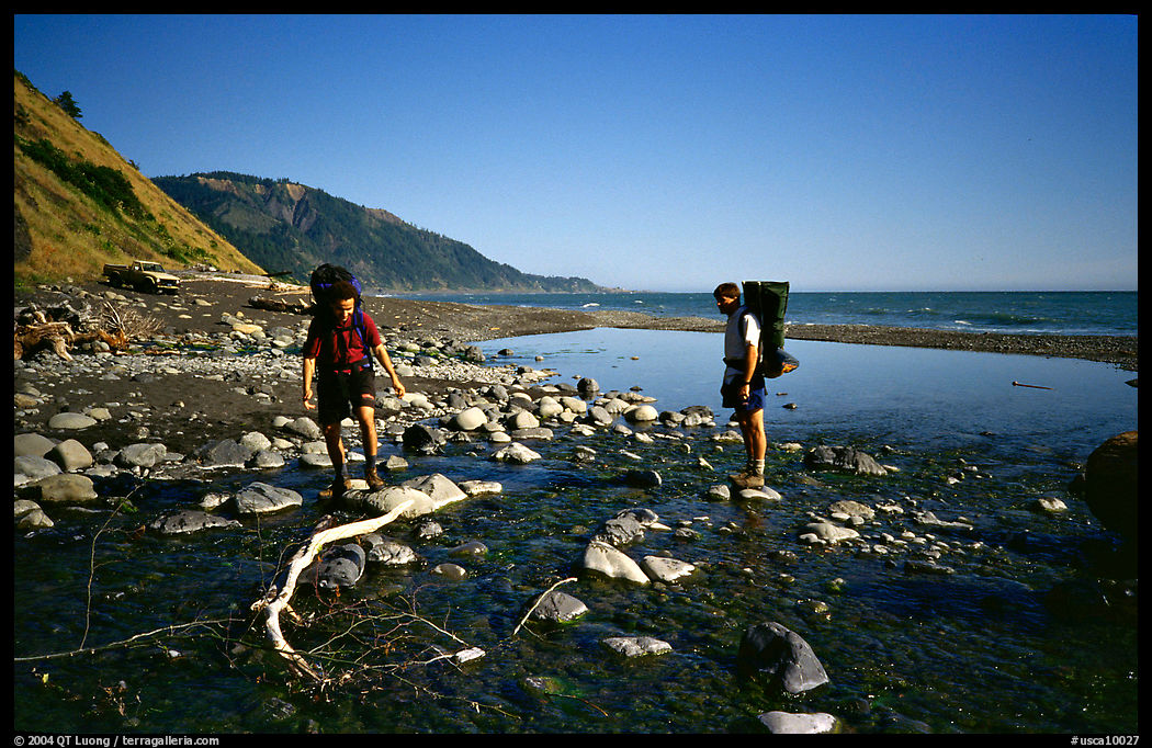 Backpackers cross a stream, Lost Coast. California, USA