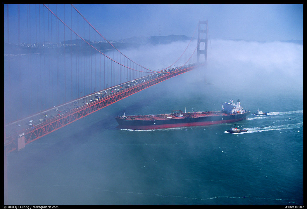 Tanker ship cruising under the Golden Gate Bridge in the fog. San Francisco, California, USA