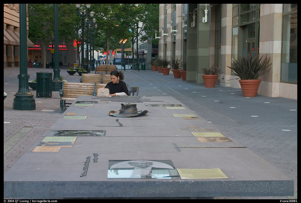 Woman sitting at a commemorative table in a downtown alley. San Jose, California, USA
