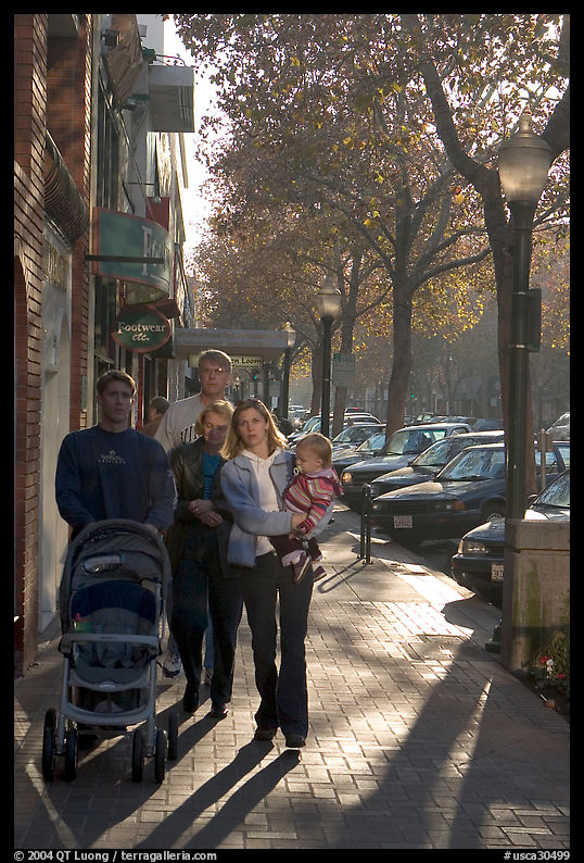 Family strolls on the sidewalk of University Avenue. Palo Alto, SF Bay area, California, USA