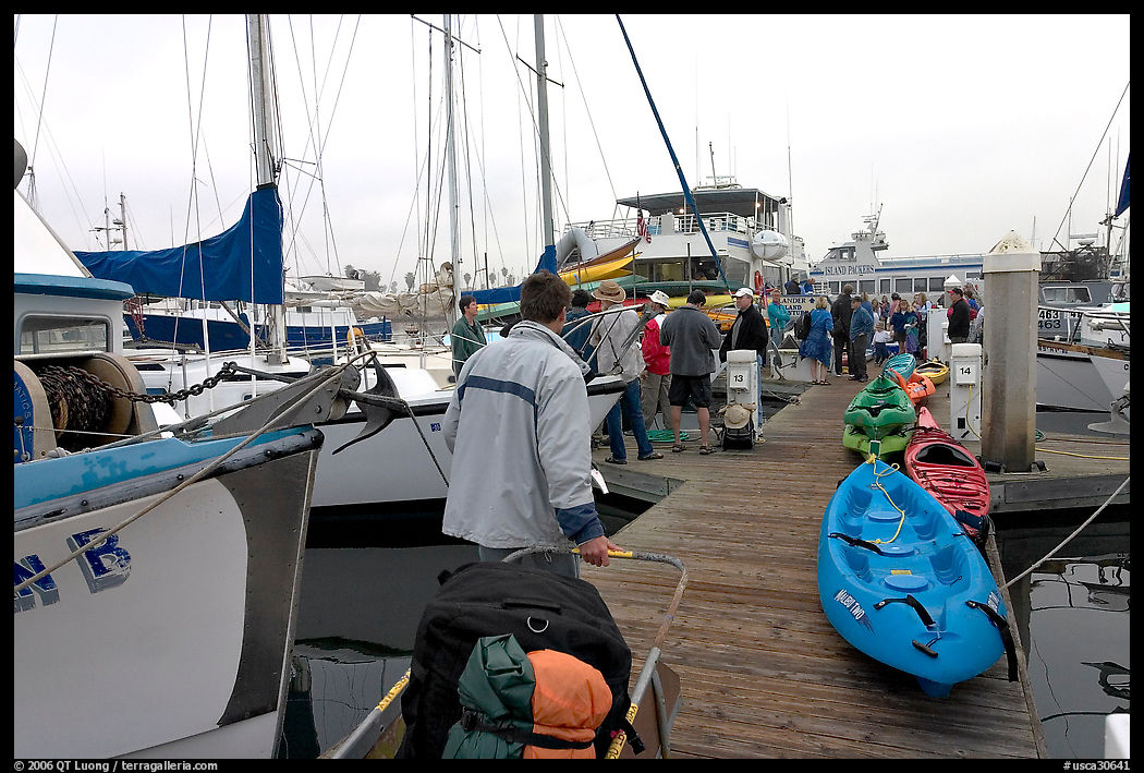 Pier with passengers preparing to board a tour boat with outdoor gear, Ventura. California, USA