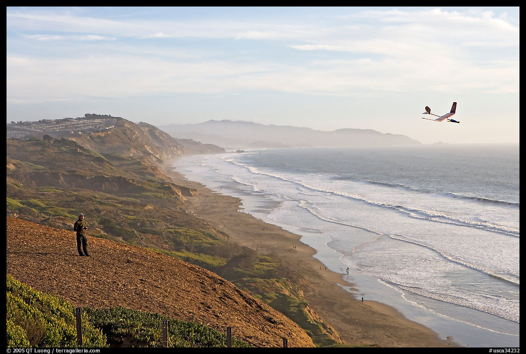 Man piloting model glider, Fort Funston, late afternoon. San Francisco, California, USA